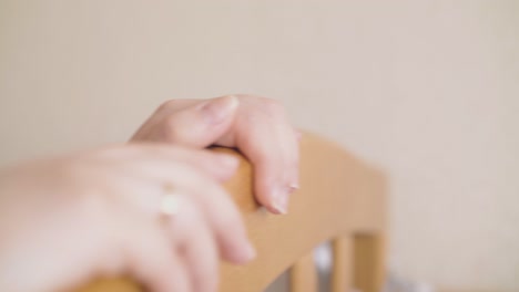 happy mommy rocks comfortable crib at light wall in room