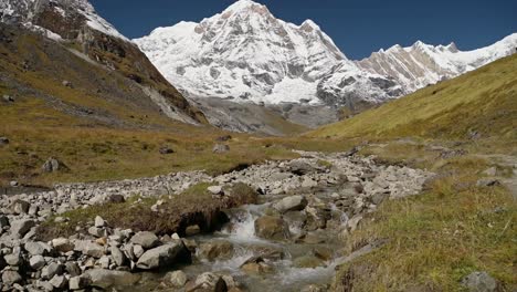 snowcapped mountains and river landscape in himalayas mountains in nepal, beautiful dramatic high altitude mountain scenery with snowy summit and large snowy mountain tops landscape