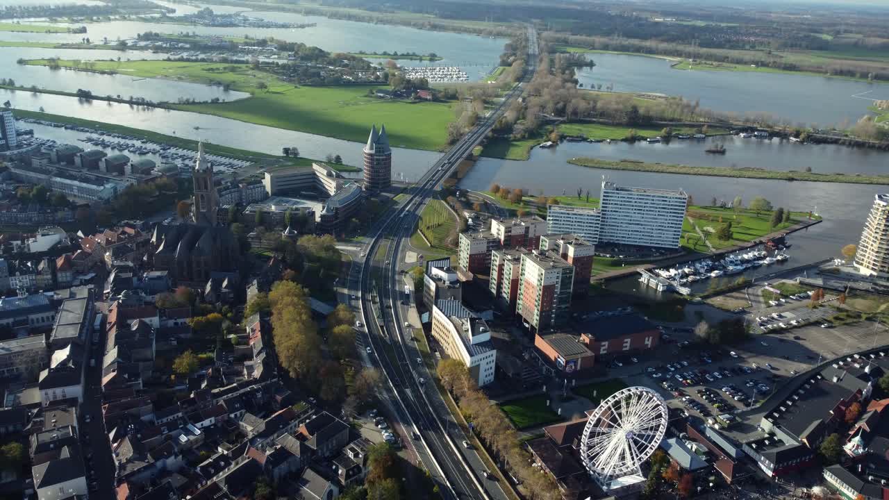 Aerial view of a cityscape with river, buildings, and a ferris wheel