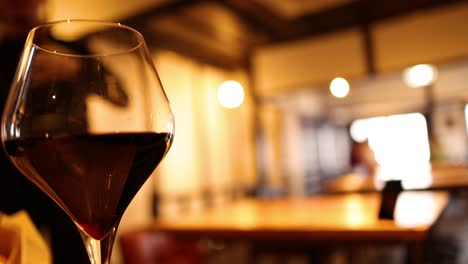 close-up of wine glass in a warm-lit bar