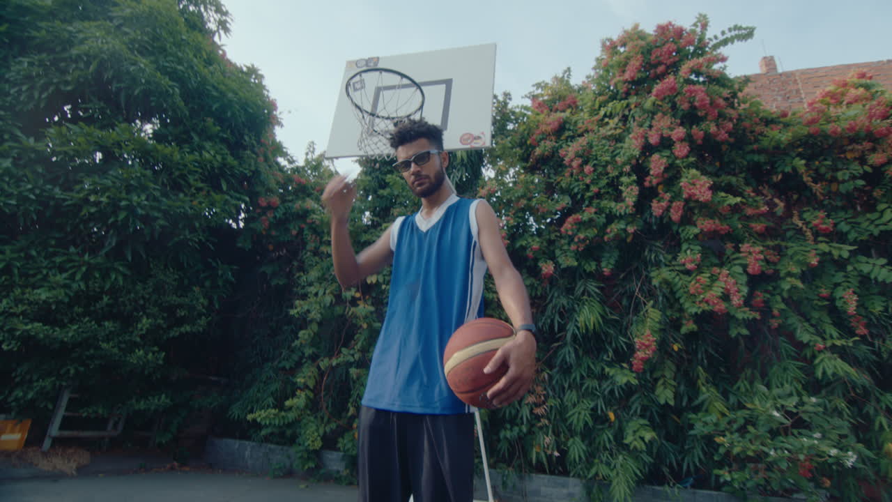 Confident Guy Posing with Basketball on Outdoor Court