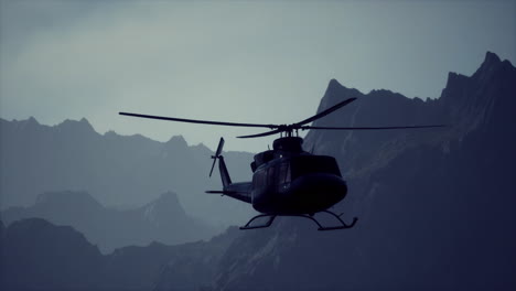 helicóptero negro volando sobre las montañas