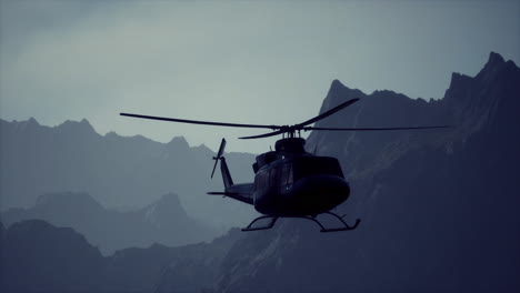 black helicopter flying over mountains