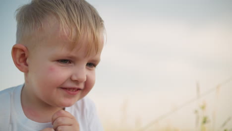 a close-up of a woman s hand offering a red apple to a happy little boy wearing a white top. the boy eagerly takes a bite, showing joy and delight in the simple pleasure of enjoying fresh fruit