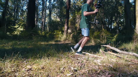 man trips on log fail holding a camera