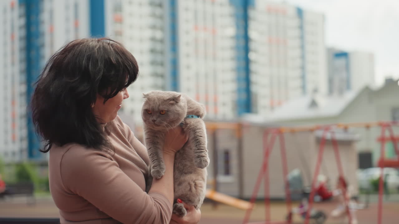 Caucasian Woman Holding Fluffy Cat Close In Courtyard With Highrise Apartments Soft Fur And Tender Gaze, Affectionate Cradle And Gentle Snuggle, Colorful Building Backdrop, Candid Closeup Capturing