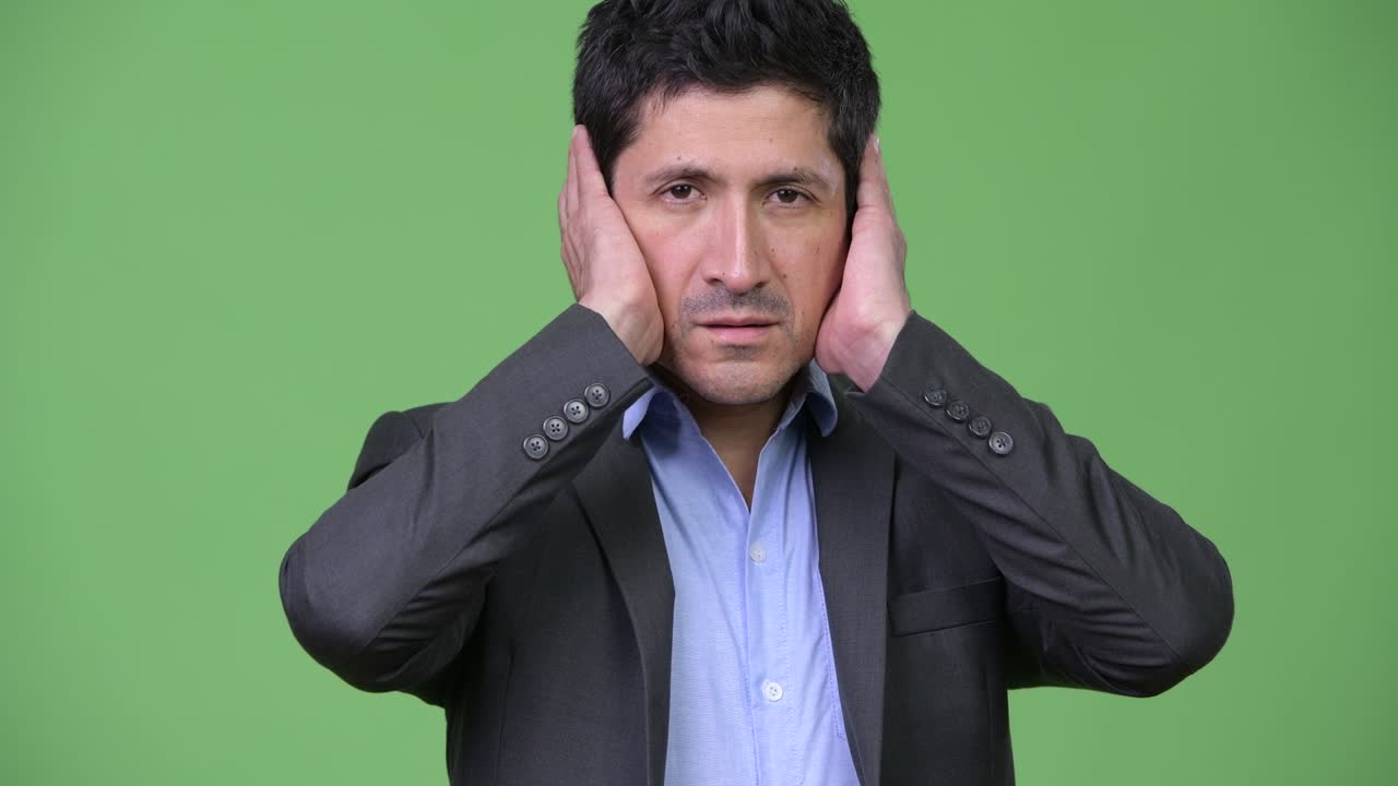 Hispanic businessman covering ears as three wise monkeys concept