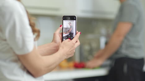 Nahaufnahme-Von-Frauenhänden,-Die-Fotos-Von-Männern-Auf-Mobiltelefonen-Machen.