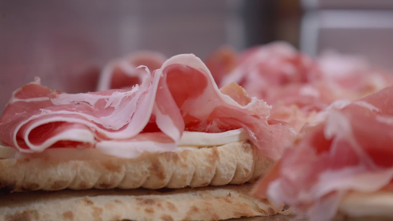 prosciutto de jamón en rebanadas. el prosciutto es un jamón crudo y curado hecho de pierna de cerdo. rebanadas de sabroso jamón en el fondo de la cocina.