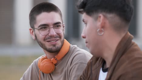 two cool friends talking and laughing together siting outdoors