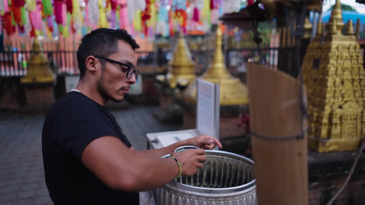 Person Pouring Water at a Temple