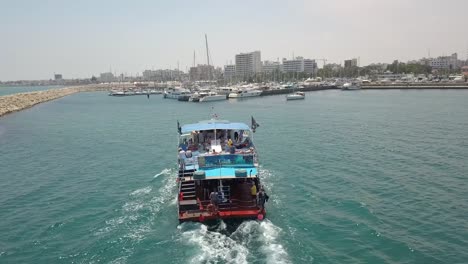 areal close shot of tourist boat returning back to park in larnaca old marina, cyprus