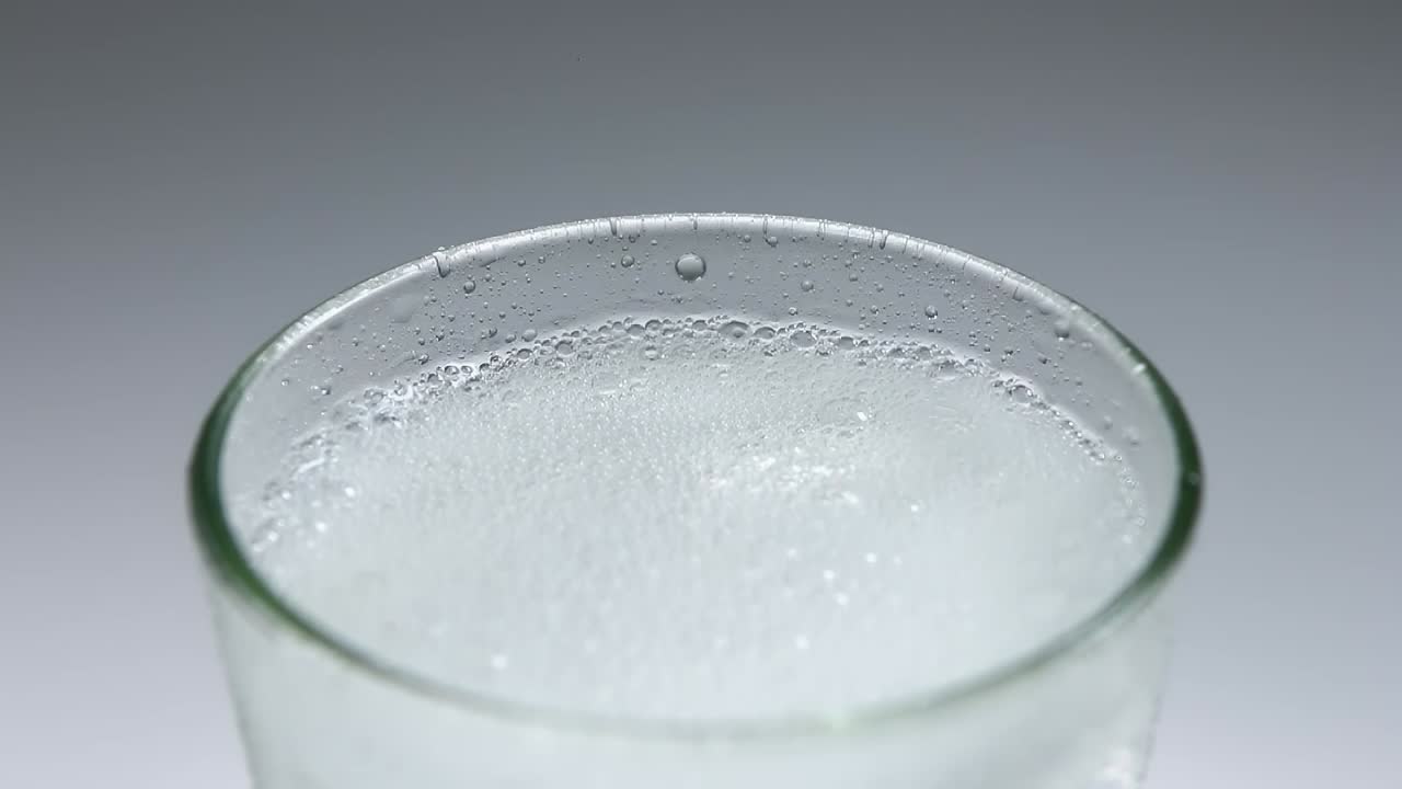 스파클링 소다 물을 얼음 큐브와 함께 유리잔에 부어 넣는 것