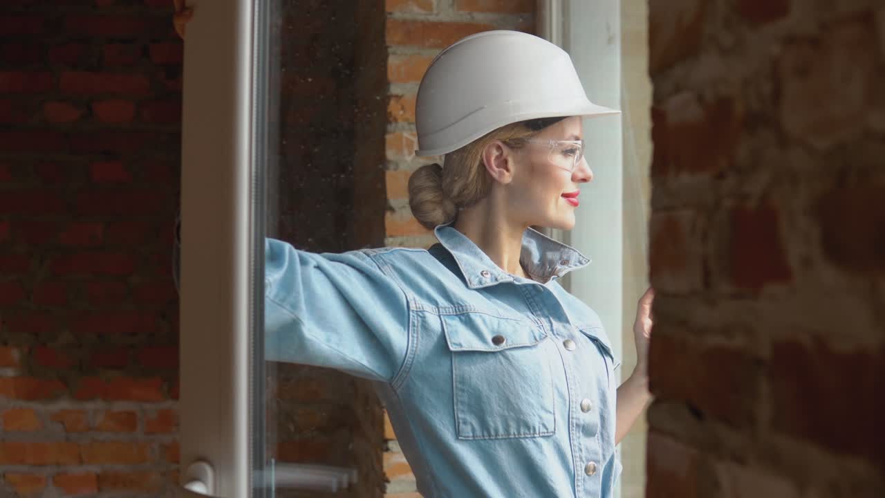 Female architect looking out the window at a construction site. The process of building housing for the family