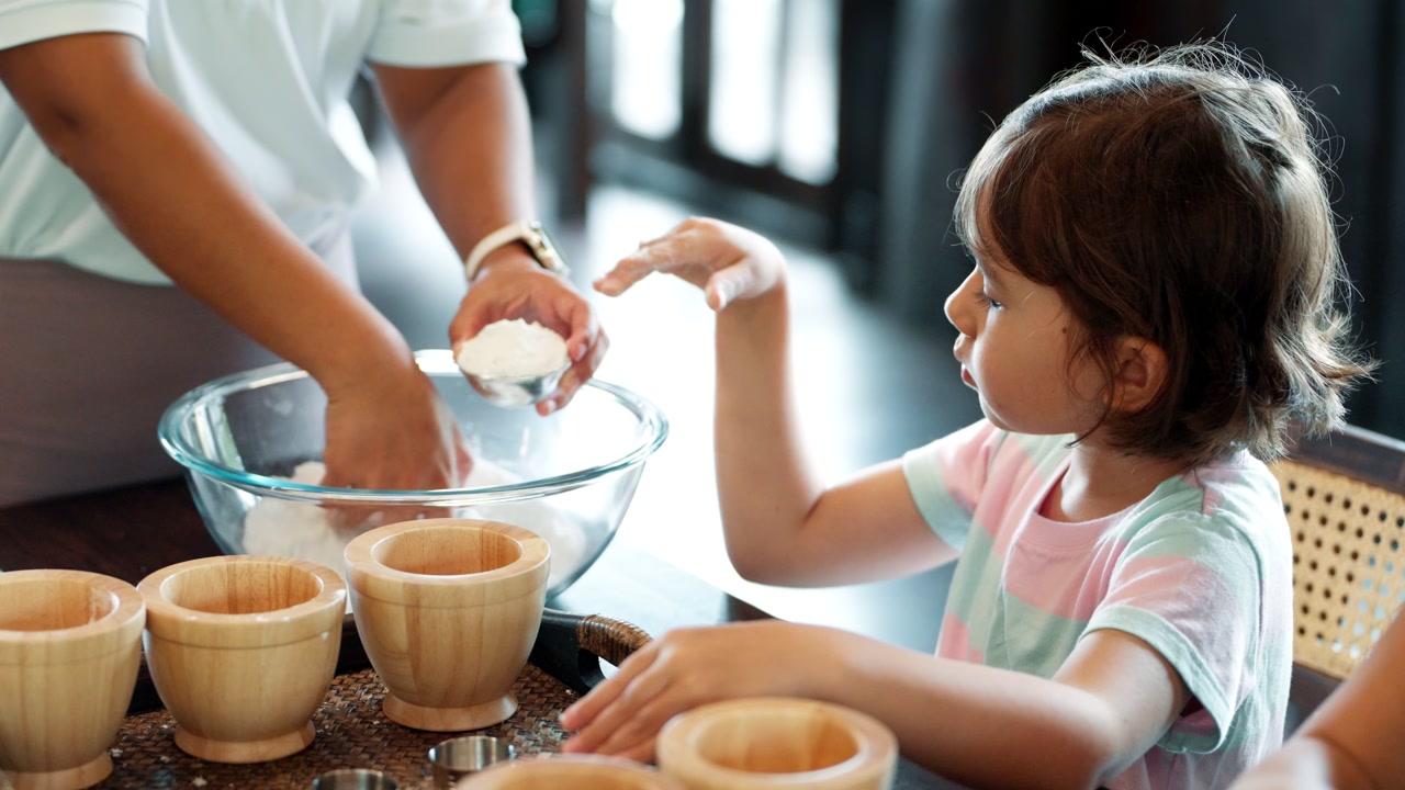 Creative soap making workshop - curious and attentive little girl watches an instructor's hands mix ingredients in a bowl, a charming moment of a child engaged in hands-on learning during a fun,