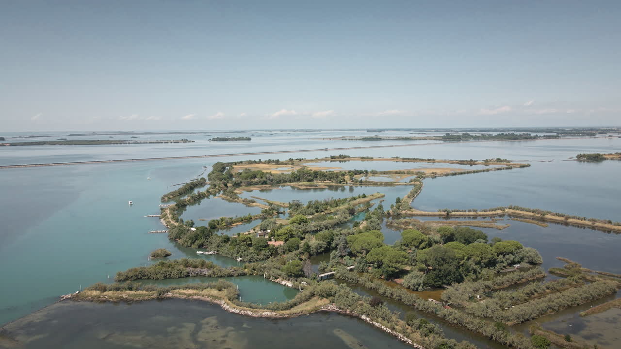 Grado Lagünü üzerinde akıcı bir şekilde alçalan drone, sakin mavi suları, alçak adaları ve sulak alan kanallarını gözler önüne seriyor; doğa belgeselleri, seyahat tanıtımları ve b-roll için ideal.