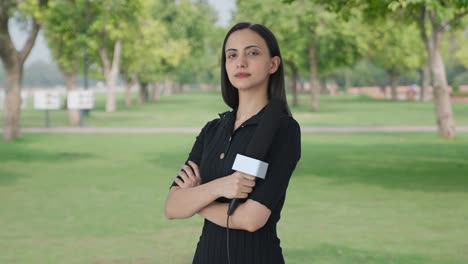retrato de una reportera india de pie con las manos cruzadas