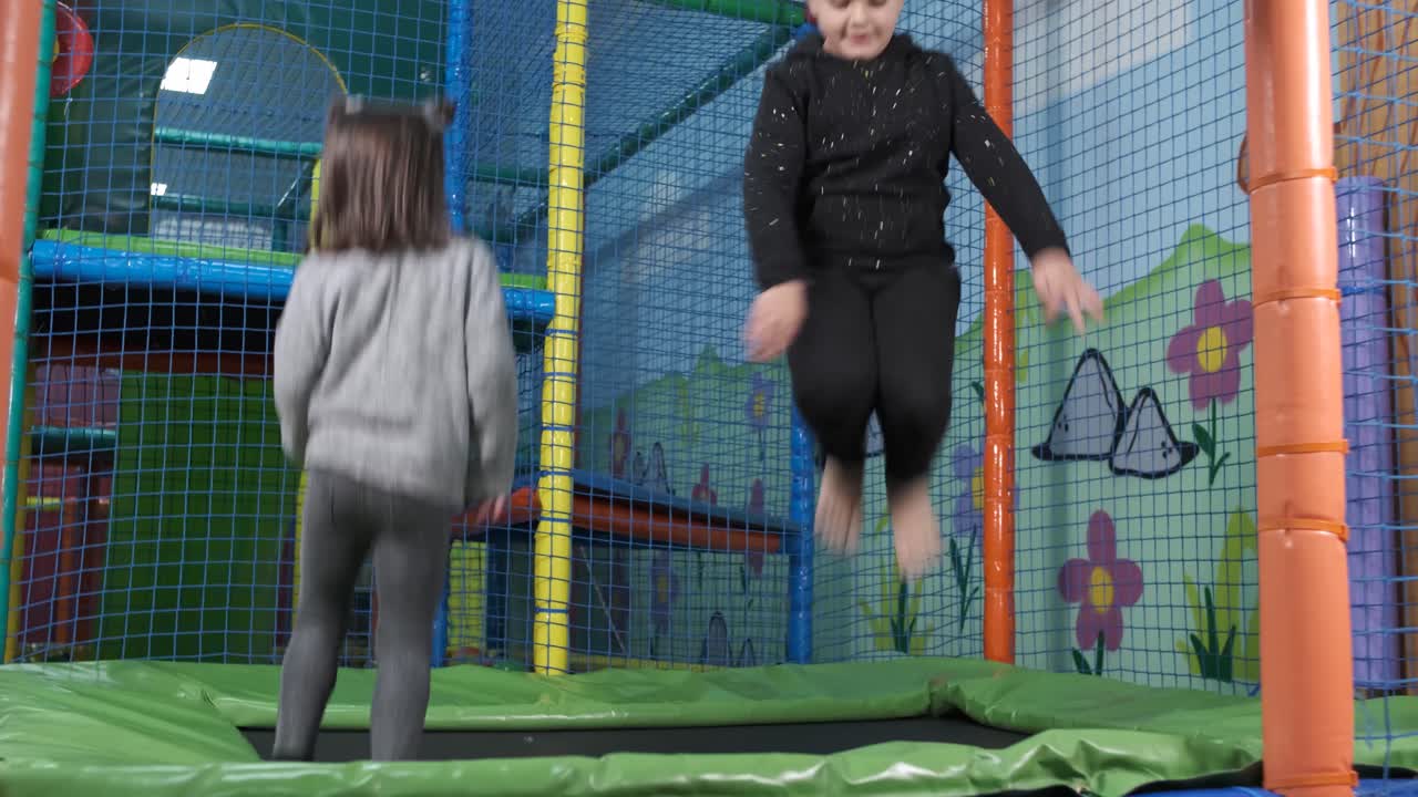 Children jump on trampolines in the children's entertainment center. Children have fun in the playground