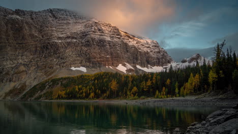 Lapso-De-Tiempo,-Amanecer-En-La-Fría-Mañana-De-Otoño-Sobre-El-Lago-Floe-Y-Las-Colinas-Nevadas-Del-Parque-Nacional-De-Kootenay,-Columbia-Británica,-Canadá