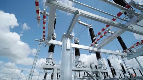 many high voltage electrical insulators in power substation against blue sky background