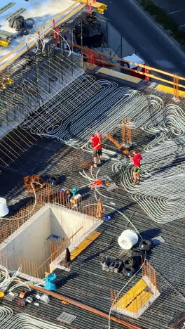 workers ready for concrete pour. workers lay steel reinforcement rods on a construction site in a city, preparing to pour concrete on a sunny day