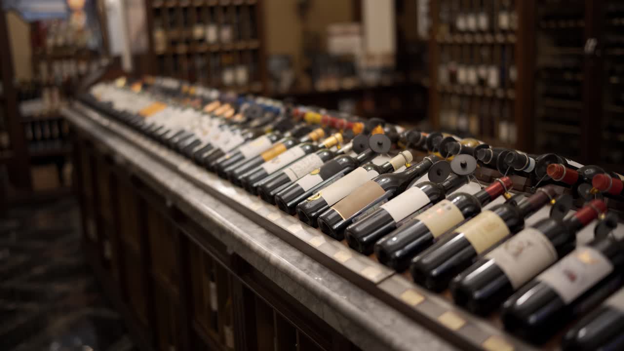 File di bottiglie di vino con vino rosso e bianco secco su legno. Profondità di campo ridotta