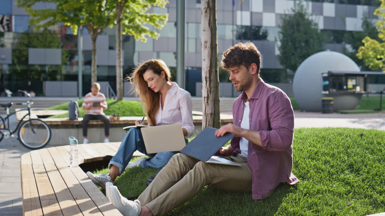 Freelancere browser på laptop sammen på gaden. Travl mand afslutter arbejde og drikker.