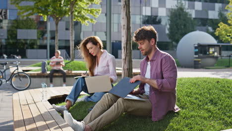 freelancers browsing laptop street together. busy man finishing work drinking