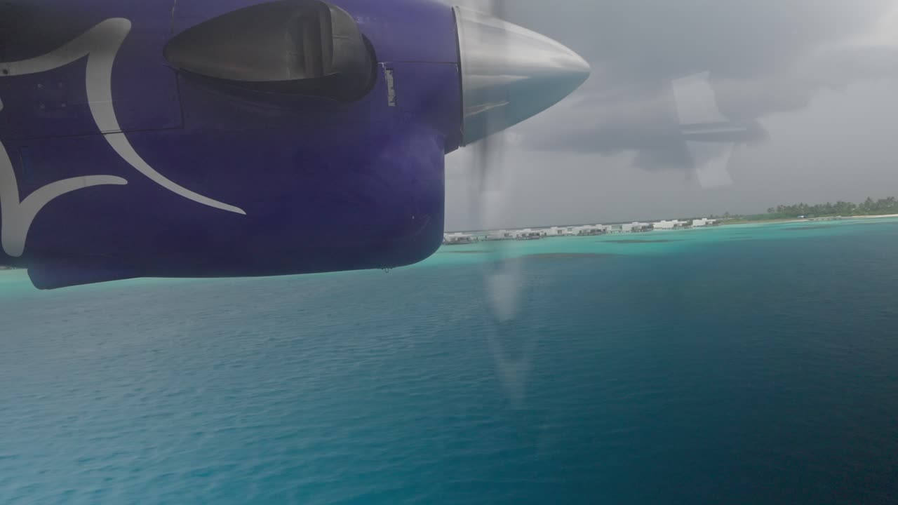 Seaplane takeoff from blue tropical water near Maldives island, window view of engine