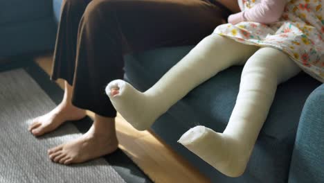 child with leg cast on sofa