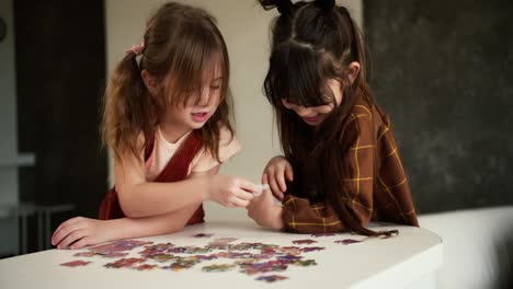 Two-diverse-children-playing-puzzles-at-home