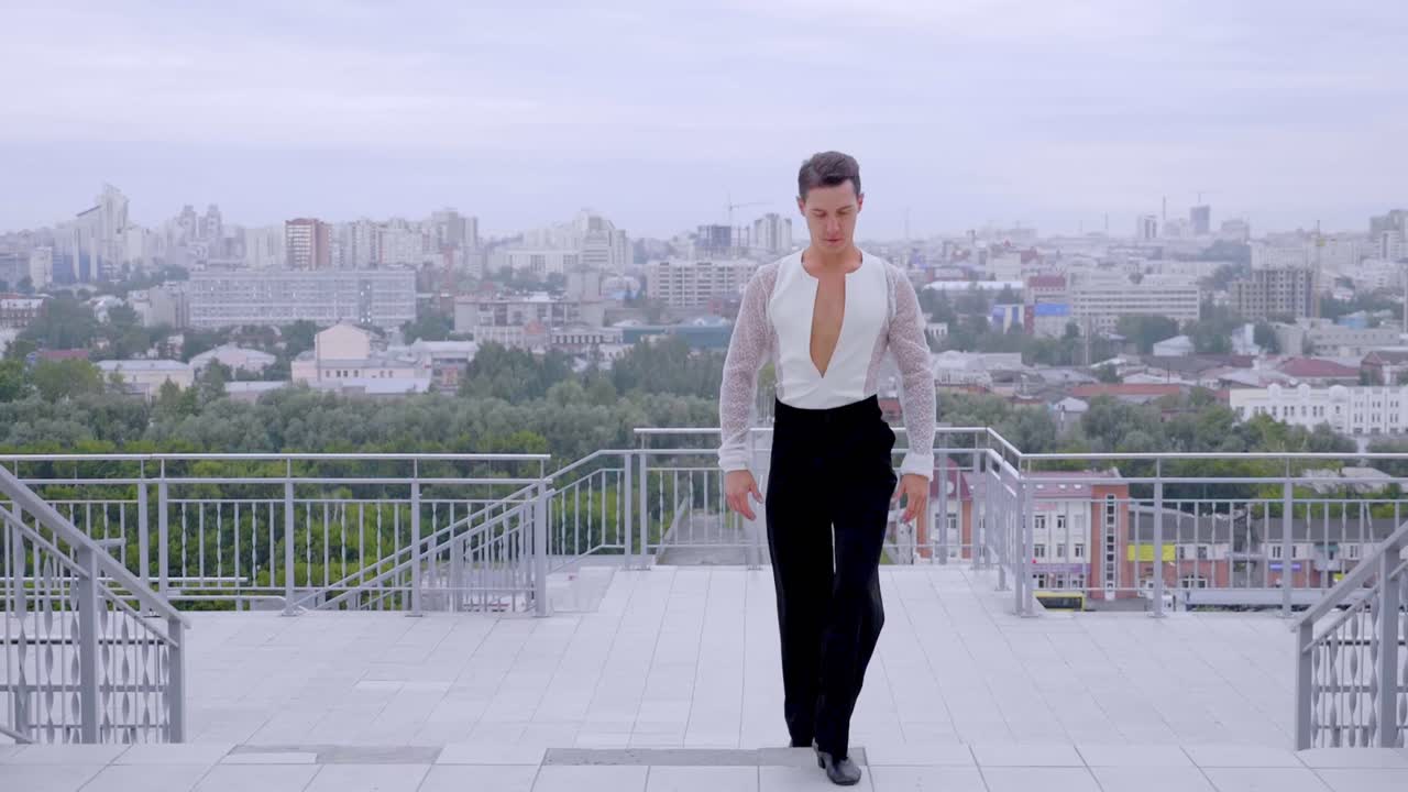 Man Dancing on Balcony with City View