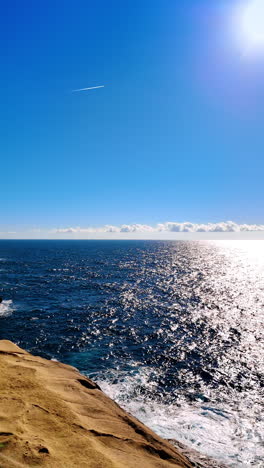 tourists walk near the xlendi tower in gozo island, malta. rocky shore and blue waterscape of the mediterranean sea. vertical video.