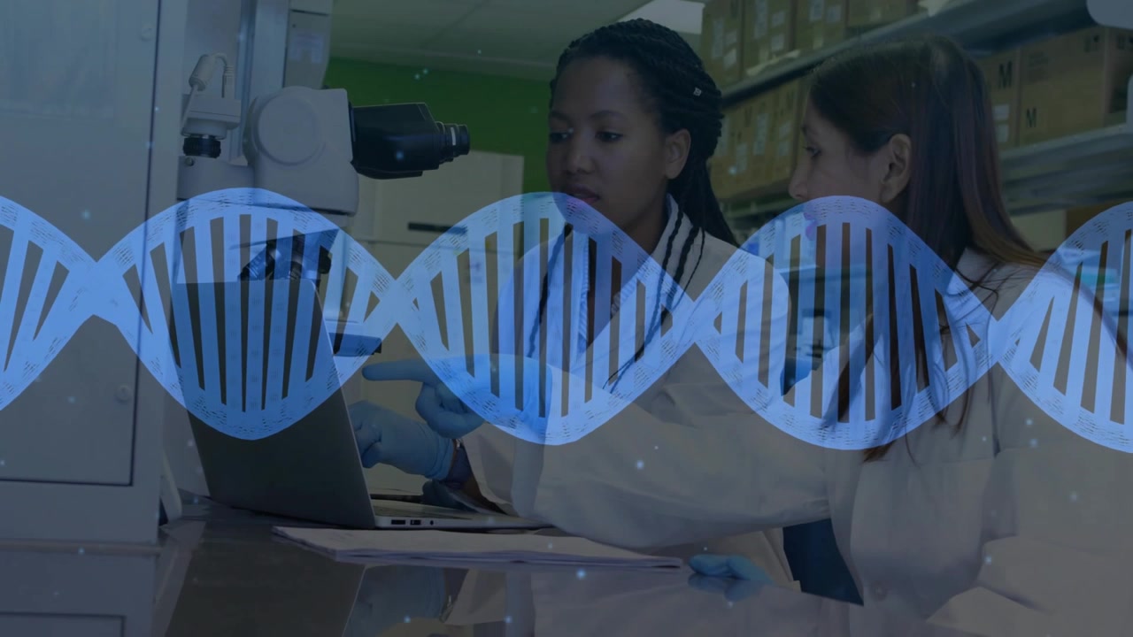 Female scientists collaborating in research lab, pointing at laptop, showcasing DNA helix overlay