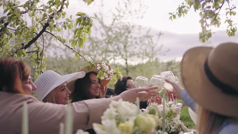 Feliz-Fiesta-Amistosa-En-Un-Fabuloso-Jardín-Mujeres-Jóvenes-Y-Alegres-Hacen-Clic-En-Copas-Con-Vino-Y-Cócteles