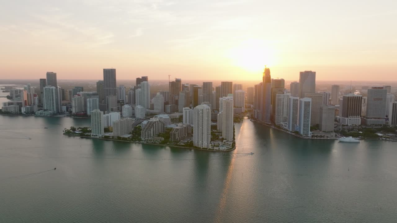 barrio urbano moderno contra el sol poniente. vista romántica de edificios de apartamentos de gran altura en el paseo marítimo y el sol bajando en el fondo. miami, ee.uu.