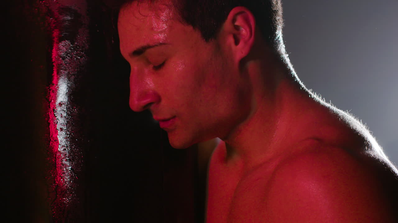 강한 남성 권투 선수 가 운동 할 때 권투 가방 을 때리고 있다