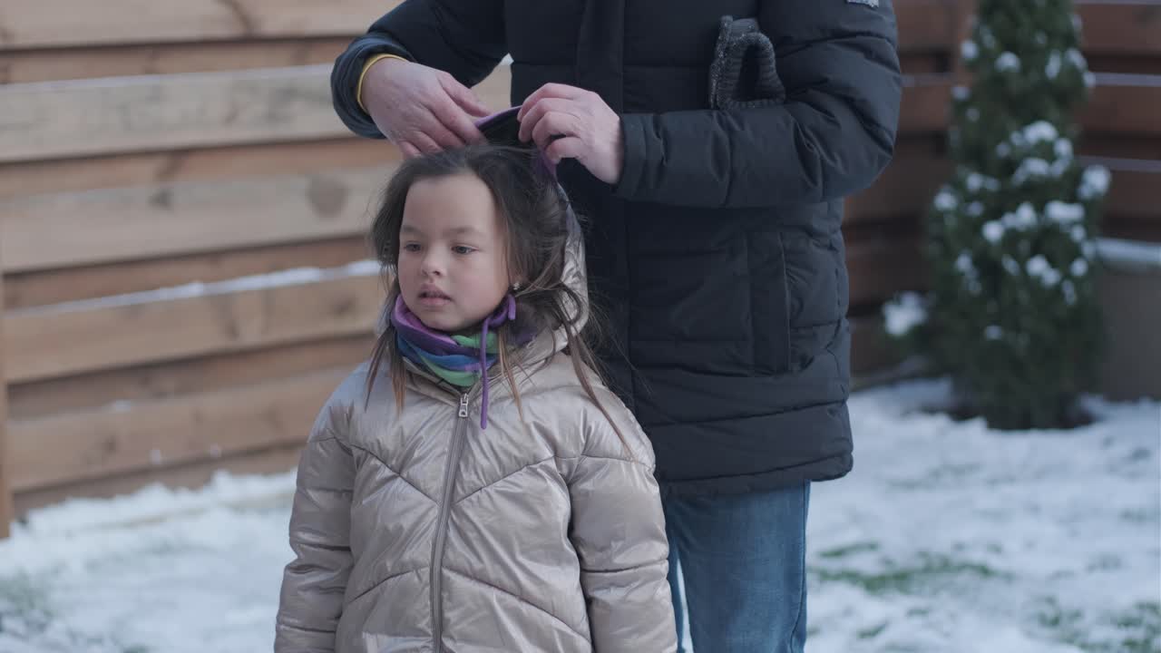 할아버지와 손녀가 눈 속에서 재미를 느끼고 있습니다.