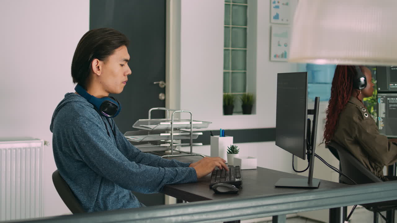 Software developer typing programming code on computer keyboard