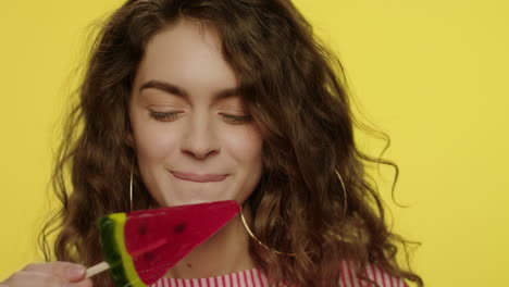 young woman licking candy watermelon