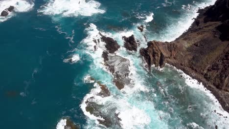 Olas-Rompiendo-En-Una-Costa-Con-Rocas-Océano-Azul-Vista-Aérea-De-Aves-No-Tripuladas