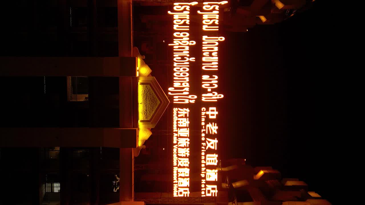 Illuminated sign for China-Lao Friendship Hotel and Southeast Asia Vacation Resort at night