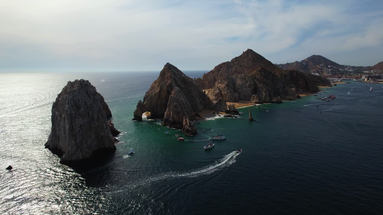 vista aérea siguiendo un barco conduciendo alrededor del cabo de cabo san lucas, méxico - dando vueltas, tiro de drones