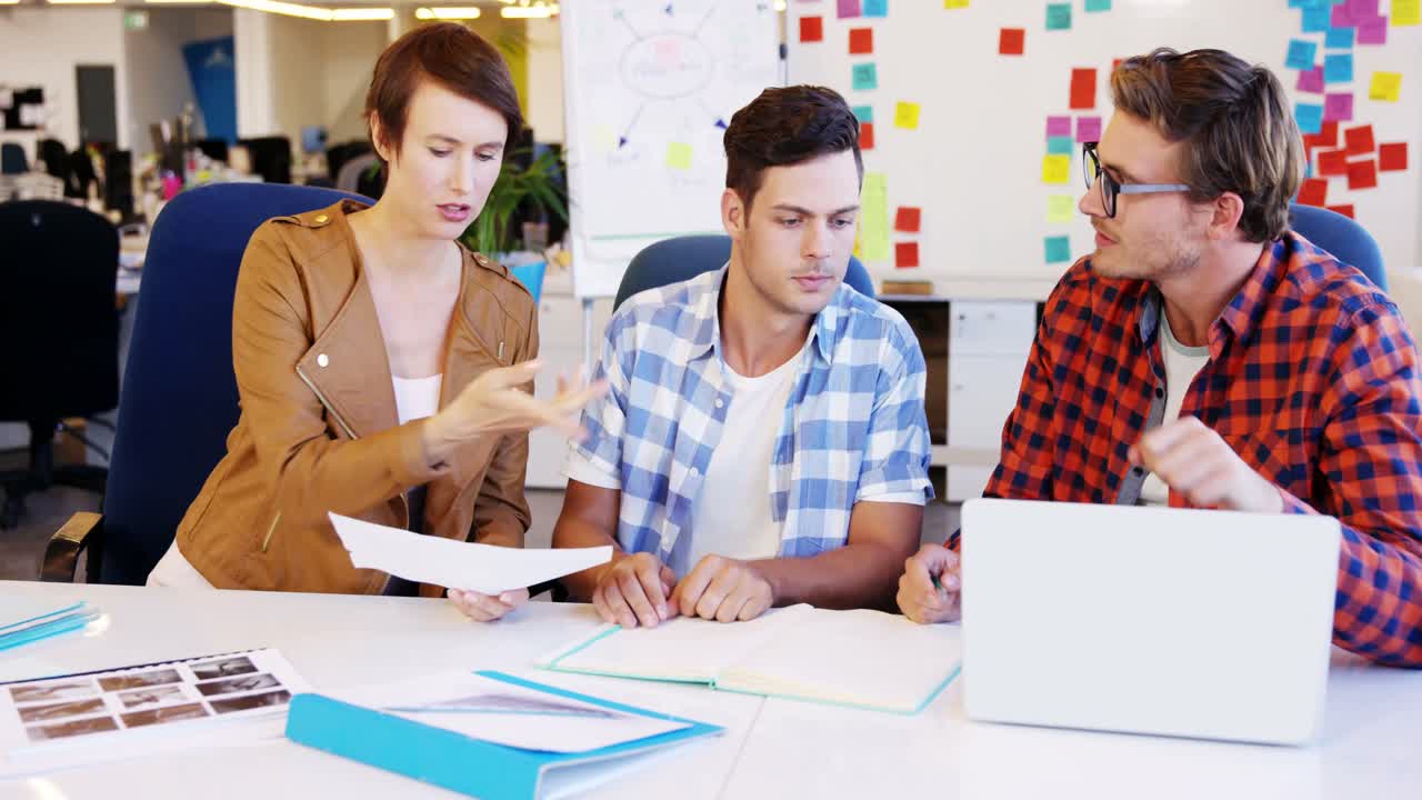 diseñador gráfico con una muestra de foto e interactuando con sus colegas