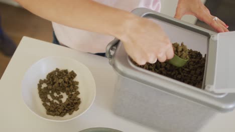 Mujer-Caucásica-Preparando-Un-Tazón-Con-Comida-Para-Su-Perro.