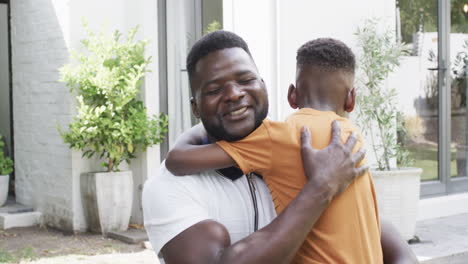 african american father hugs son outdoors