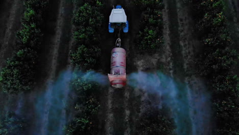 agricultural tractor spraying herbicide on orange plantation in brazil