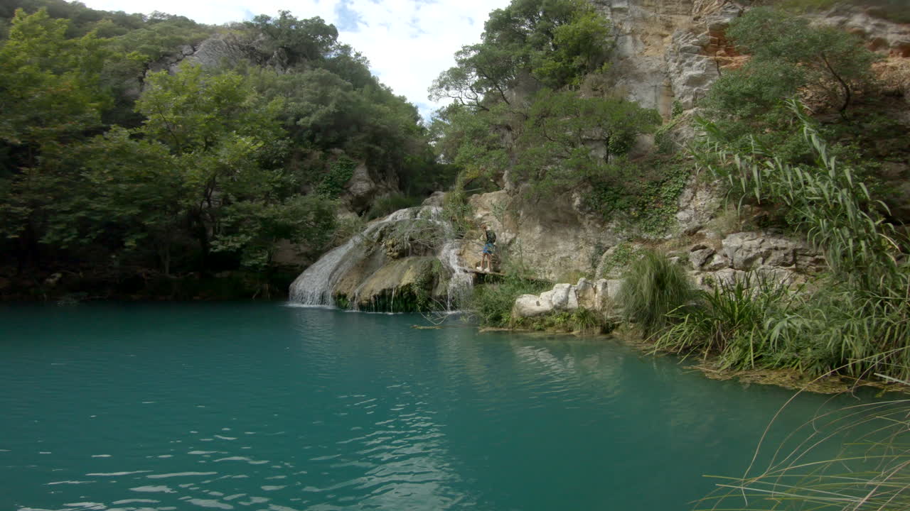 una mujer camina por las cascadas de polylimnio en grecia.