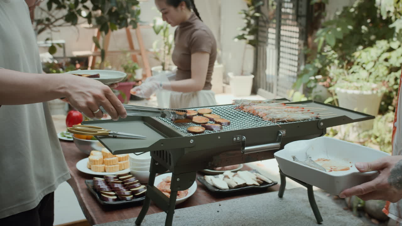 People Grilling Aubergine and Shrimps in Backyard