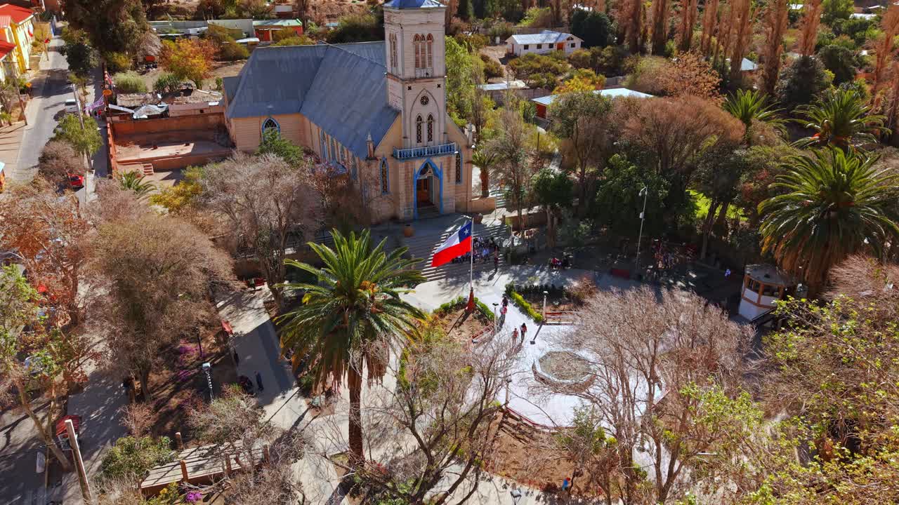 Aerial view of Plaza Pisco Elqui, a wine-producing town in the Elqui Valley in northern Chile on a sunny day with a group of tourists in front of the main church